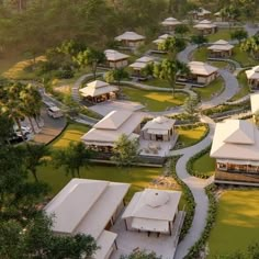 an aerial view of a resort surrounded by lush green trees and grass, with lots of white tents in the background