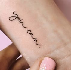 a woman's foot with the word love tattooed on her left ankle and pink nail polish