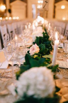 the table is set with white flowers and candles for an elegant wedding reception or special event