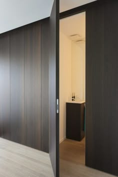 an open door leading into a room with wood floors and white walls in the background