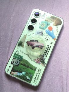 a cell phone case with stickers on it sitting on a purple sheeted surface