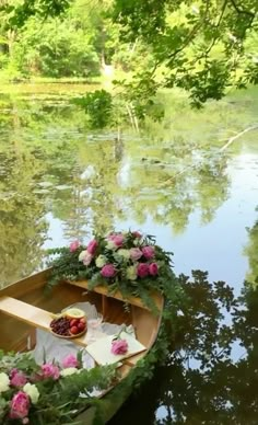 there is a boat with flowers on it in the water and trees around it,