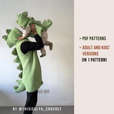 a person in a crocheted alligator costume holding a child