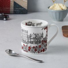 a coffee cup and spoon sitting on a table next to a box of ice cream