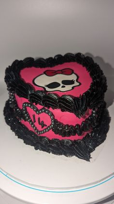 a pink and black cake with a skull on it