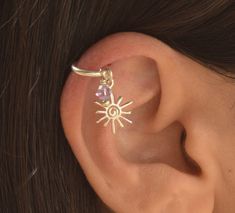 a woman's ear is shown with the sun and star piercing