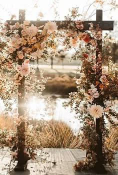 an outdoor wedding setup with flowers and greenery on the altar, overlooking a lake