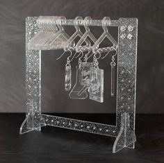 an acrylic frame with earrings hanging from it