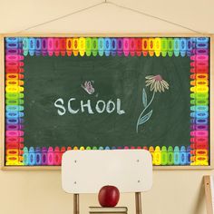 a chalkboard with the word school written on it next to a chair and an apple