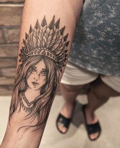 a woman with a headdress tattoo on her arm