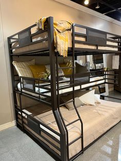 bunk beds with yellow pillows and blankets on them in a room that has carpeted flooring