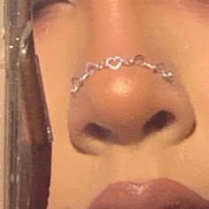 a woman with a nose chain attached to her nose