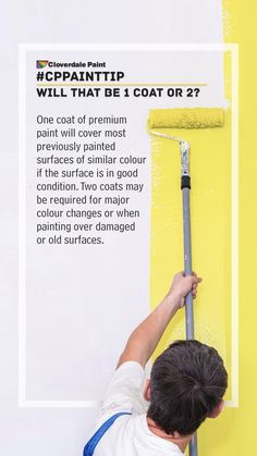 a man is painting the wall with yellow paint and white advertisment on it