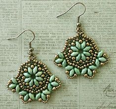 two pairs of green beaded earrings sitting on top of a piece of paper