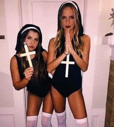 two women dressed in costumes standing next to each other with crosses on their heads and hands