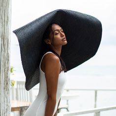 a woman wearing a large black hat on top of her head