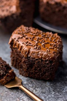 there is a piece of cake with chocolate frosting on it and a fork next to it