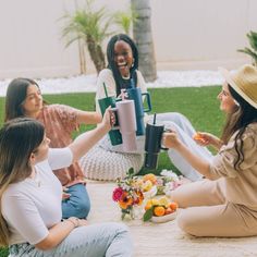 four women sitting on the ground having fun with each other