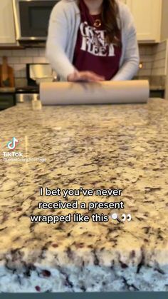 a woman standing in front of a counter top with a message on it that reads, i bet you've never received received a present wrapped like this