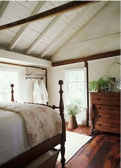 a bed sitting in a bedroom next to a dresser and window on top of a hard wood floor