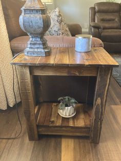 a wooden table with a potted plant on top of it next to a couch