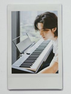 a polaroid photo of a man playing the piano with his head resting on an electronic keyboard