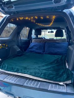 there is a bed in the back of a truck with lights on it's sides