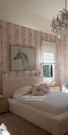 a bedroom with pink and white wallpaper, a chandelier and a large bed