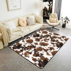 a living room with a cow hide rug on the floor next to a couch and chair