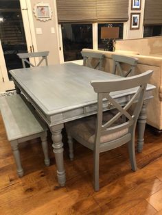 a table and chairs in a room with hardwood floors