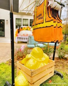 yellow construction vests are in a crate on the grass