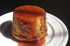 a piece of cake sitting on top of a white plate covered in caramel sauce