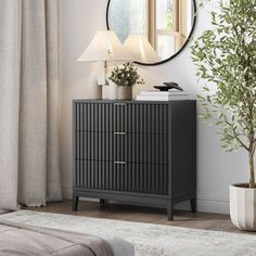 a black dresser with a mirror above it and a plant in front of the window