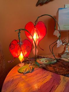 two red heart shaped lamps sitting on top of a table next to a lamp shade