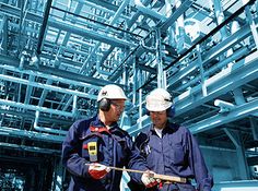 two men in hardhats standing next to each other