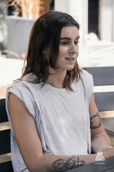 a woman with tattoos sitting on a bench