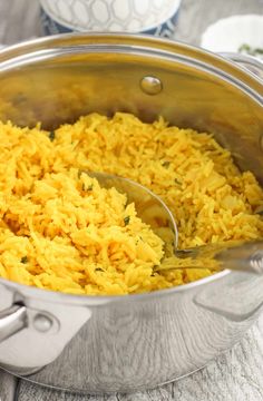 a large pot filled with yellow rice on top of a table