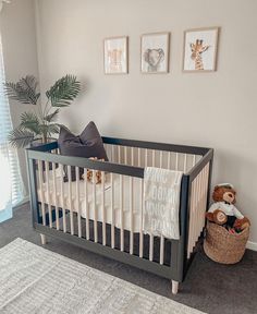 a baby crib with stuffed animals and pictures on the wall