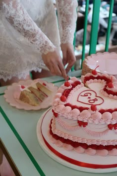 a woman cutting into a heart shaped cake