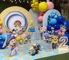 a birthday party with balloons, cake and decorations on a table in the shape of minionsettes