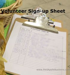 a clipboard with a sign - up sheet attached to it next to a basket