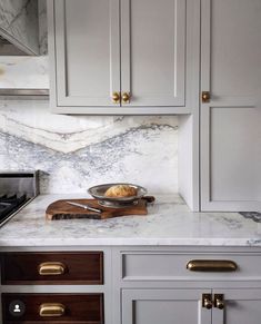 a kitchen with marble counter tops and gold handles