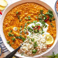 a white bowl filled with rice, beans and green onion garnished with cilantro