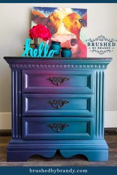 a blue painted dresser with flowers on top