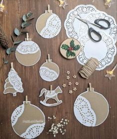 christmas ornaments are displayed on a table with scissors and other crafting supplies around them