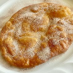 a powdered pastry is sitting on a white plate