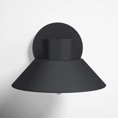 a black wall light on a white wall next to a gray lamp shade that is attached to the wall