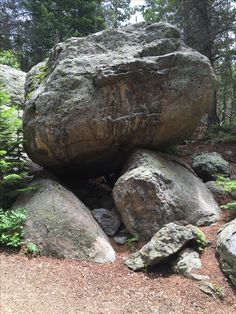 a large rock sitting in the middle of a forest