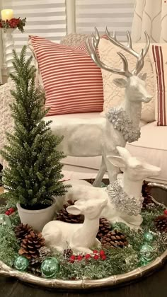 a tray with christmas decorations on it and a deer figurine in the center