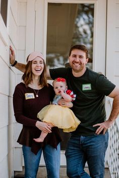 a man, woman and baby standing on the steps of a house with their arms around each other